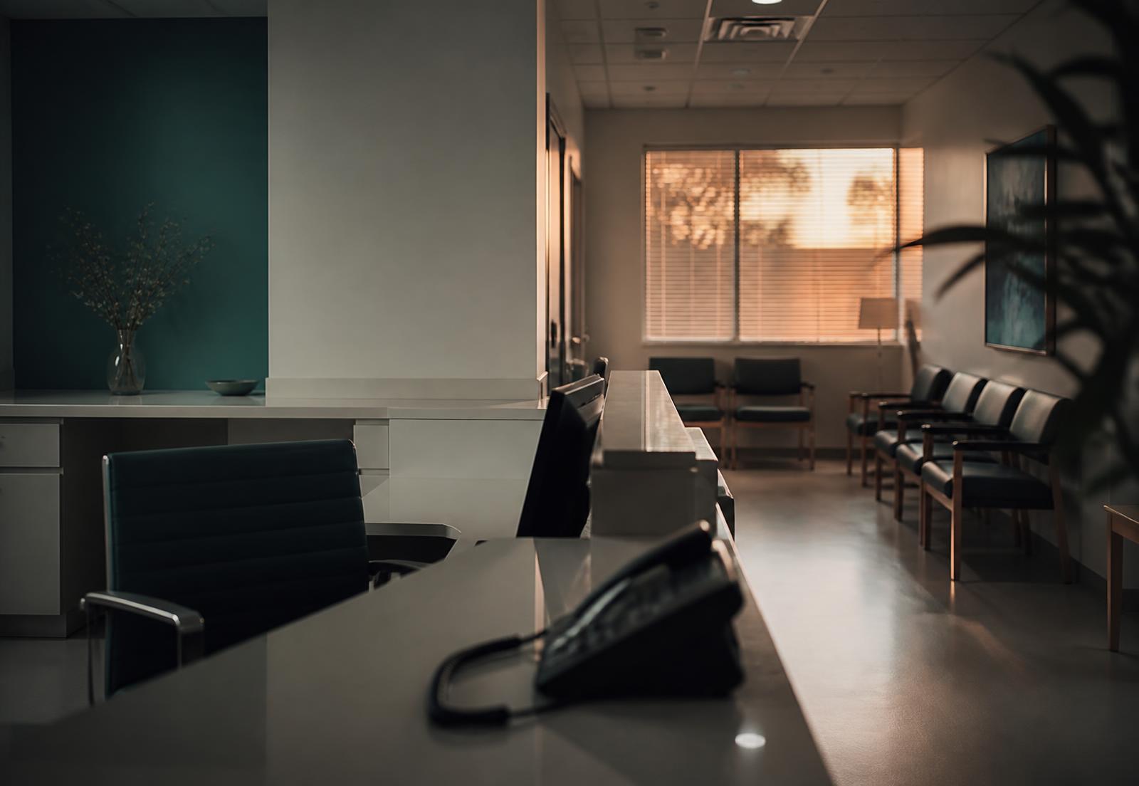 Clinic reception at dusk after the desk closes